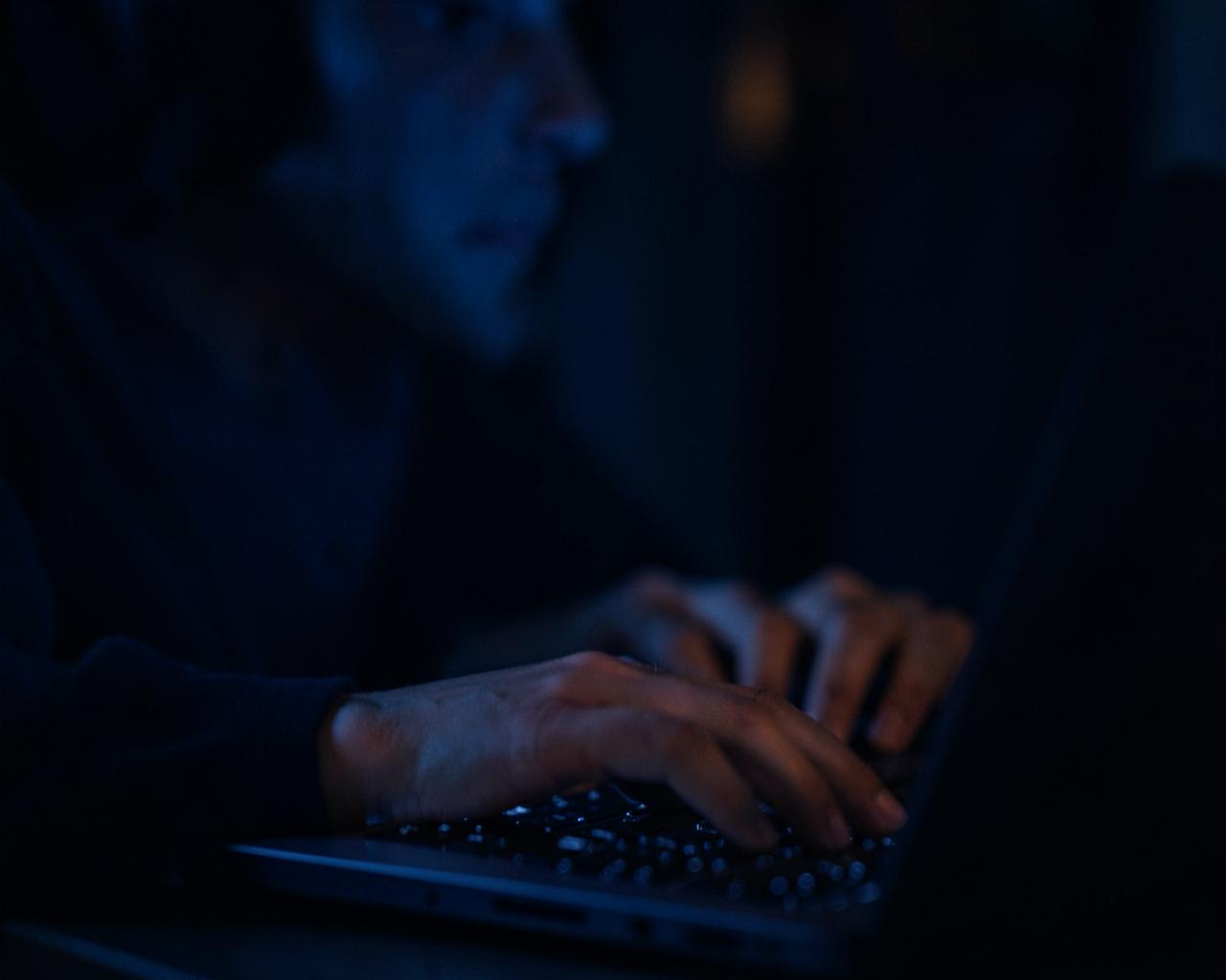 Mãos digitando um relato em um computador, à noite